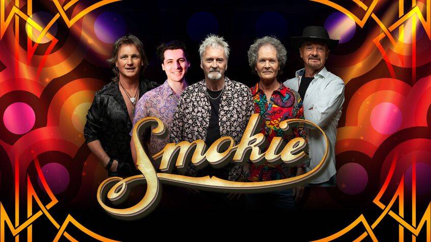 Fünf männlich gelesene Personen stehen nebeneinander vor buntem Hintergrund. Schriftzug "Smokie" im Vordergrund.
