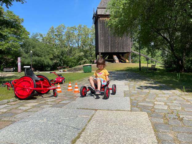 Losrollen - Verkehrsparcours und Verkehrsschilder im Museumspark – Ein Kind fährt mit einem Trettauto im Museumspark