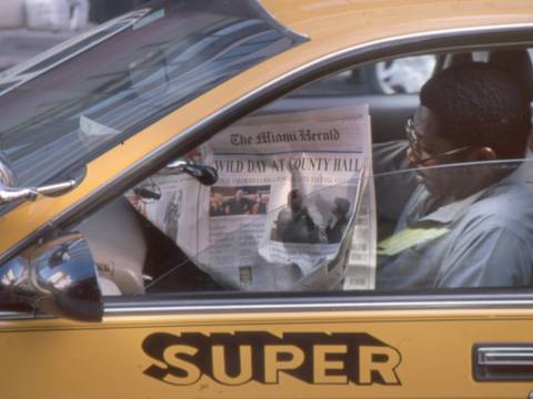 Zeitungslesender in Miami (USA), 2000 – Der Fahrer eines gelben Autos mit der Seitenaufschrift liest eine Zeitung