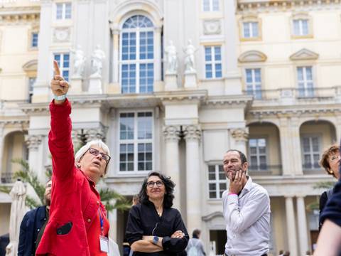 Führung im Humboldt Forum – Führung im Humboldt Forum. Eine Frau deutet im Hof in die Höhe.