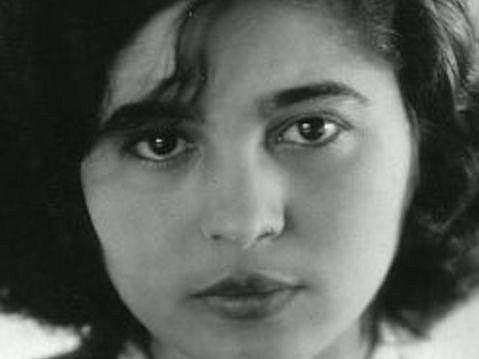 Mascha Kaléko – Person mit mittellangem, dunklem Haar blickt direkt in die Kamera. Gesichtsausdruck neutral. Schwarz-weiß Fotografie.