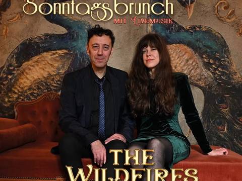 Sonntagsbrunch mit Livemusik – Zwei Personen auf einem Sofa vor einem Pfauenbild. Text: Sonntagsbrunch mit Livemusik. THE WILDFIRES. 1.11. 13-15 UHR. Wriezen Str. 6 13359 Berlin