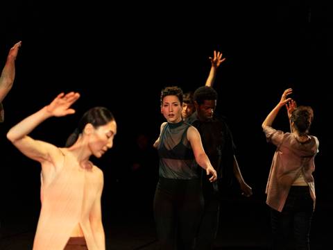 for the time being 1 – Mehrere Performer*innen, tanzend vor schwarzem Hintergrund