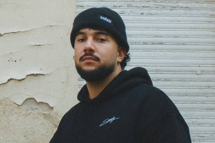 Künstler Savvy steht vor einer Häuserwand