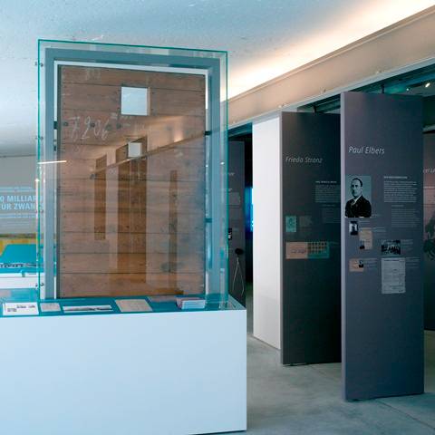 Blick in die Ausstellung – Arrestzellentür Fritz Werner AG Berlin, 1942 – 1945Die Maschinen- und Munitionsfabrik Fritz Werner sperrte ihre Zwangsarbeiter (2600 waren es allein Ende 1942) bei Regelverstößen hinter dieser Zellentür ein.