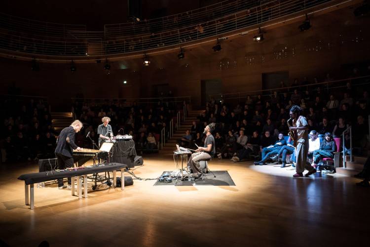 20 Jahre Radialsystem: In C – special performance 2 – Vier Musiker auf der Bühne in einem Lichtkegel.