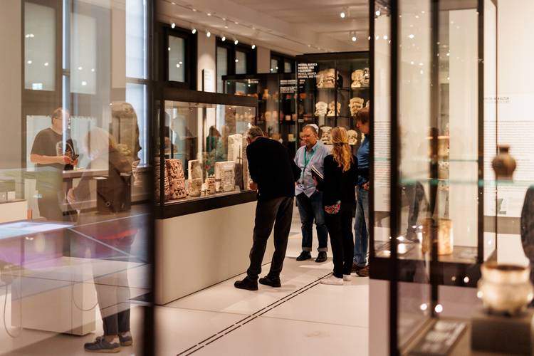 Besucher*innen einer Führung im Bereich "Grafische Kommunikationssysteme in Mesoamerika" des Ethnologischen Museums – Besucher*innen einer Führung im Bereich "Grafische Kommunikationssysteme in Mesoamerika" des Ethnologischen Museums