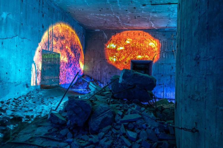 Klang- und Lichtinstallation: Seafoam Palace presents »Roadside Picnic« – Innenraum des Flakturms Humboldthain mit Trümmern und zwei farbigen Lichtprojektionen an den Betonwänden als Teil der Klang- und Lichtinstallation »Roadside Picnic« von Seafoam Palace.