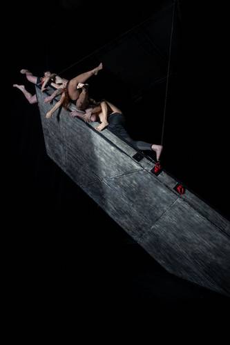Tanz im August: HORNFUCKERS 1 – Mehrere Performer*innen auf klammern sich an eine spitze, nach oben ragende Hornskulptur.