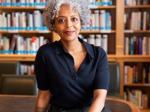 Portrait der Autorin Maaza Mengiste – Ein Frau sitzt vor einem Bücherregal