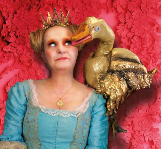 Märchen im Glaspalast: Schneewittchen | Die goldene Gans – Person in blauem Kleid und Krone mit goldener Puppe eines Vogels auf der Schulter, roter Hintergrund mit Blumenmuster.