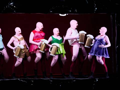 ÜBERGEWICHT, unwichtig: UNFORM – Sechs Darsteller*innen in pinken Kostümen mit aufblasbaren Biergläsern.