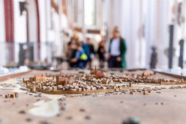 Modell der mittelalterlichen Stadt Berlin im Museum Nikolaikirche – Modell der mittelalterlichen Stadt Berlin im Museum Nikolaikirche, im Hintergrund unscharf Besucher und das Innere des Kirchenschiffs