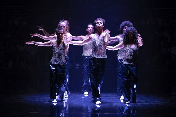 Tanz im August: F*cking Future 3 – 6 Performer*innen in Kettenhemden auf einer bläulich beleuchteten Bühne.