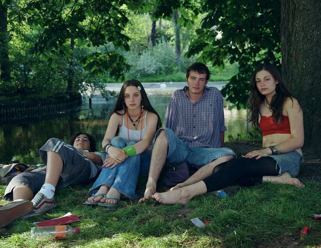 Rineke Dijkstra, Vondelpark, Amsterdam, June 10, 2005 – Fotografie: Vier junge Personen sitzen bzw. liegen in Sommerkleidung in einem Park. Ihr direkt ist direkt in die Kamera gerichtet.