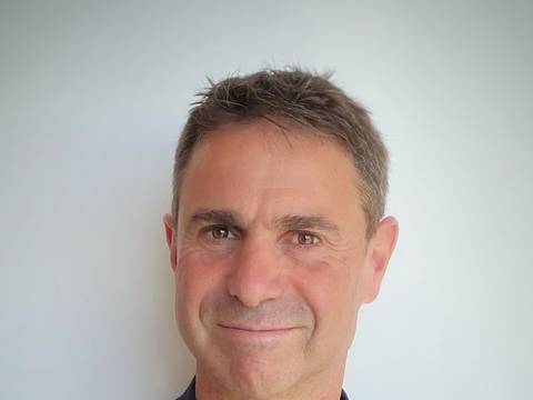 Shalom Zuckerman – Person mit kurzen, dunklen Haaren in schwarzem Hemd vor hellem Hintergrund. © Shalom Zuckerman