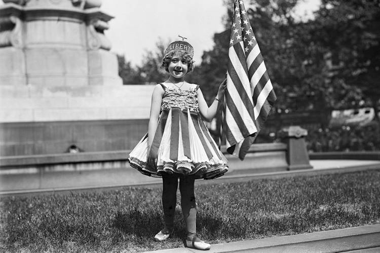New England Holiday: Ein Mädchen feiert den 4. Juli 1916 als personifizierte Freiheit. – Kostümiertes Mädchen mit US-Flagge