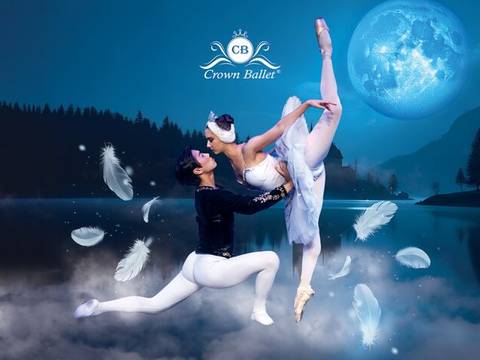  – Zwei Balletttänzer*innen, eine hebt die andere, umgeben von Federn vor einem See bei Vollmond. Text: CB Crown Ballet.