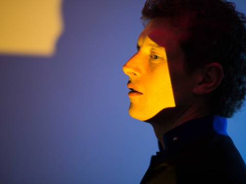 © Edith Buttingsrud Pedersen – Person im Profil, von gelbem Licht beleuchtet, blaue Wand im Hintergrund.