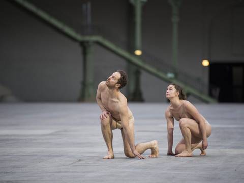 herses, duo (Club Amour) – Ein Tänzer und eine Tänzerin knien auf einer leeren Bühne und schauen nach oben.
