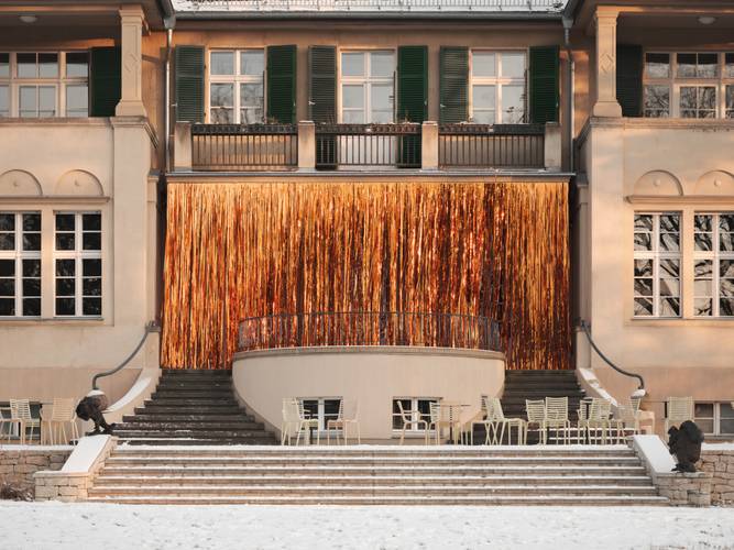 Rey Akdogan, Slit drape (C), 2026, Installationsansicht Rey Akdogan. Carousels, Haus am Waldsee, 2026, Foto: Julian Blum – Ansicht des Haus am Waldsee mit einem kupferfarbenen Lametta-Vorhang vom Balkon abhängend