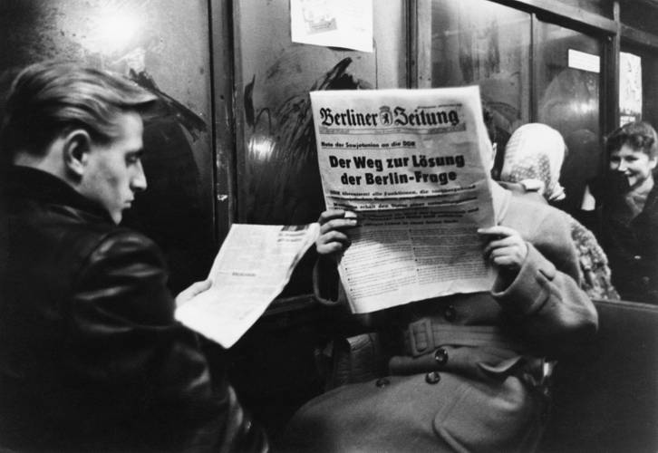 Konrad Hoffmeister, Lesende S-Bahnfahrer (Alexanderplatz), Berlin (Ost) 1957/1958. Die abgebildete Berliner Zeitung trägt die Schlagzeile „Der Weg zur Lösung der Berlin-Frage“.