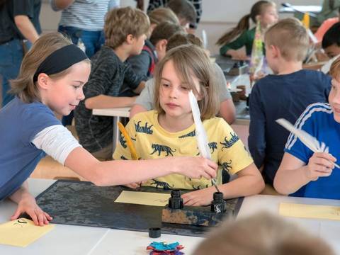 Im Museumslabor schreiben Kinder mit Tinte und Feder – Kinder im Museumslabor schreiben mit Tinte und Feder