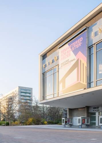 Schnepp Renou, Kino International, 2026, Entwurf: Kollektiv Josef Kaiser – Außenaufnahme des Kino International (hier als Ausschnitt) mit großem Plakat: "REMASTERED FOR MASTERPIECES", "DAS KINO INTERNATIONAL IST ZURÜCK". Gebäude und Bäume im Hintergrund.