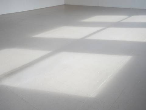 Gianna Surangkanjanajai, Removed, 2025, Courtesy die Künstlerin – Grauer Boden, darauf zeichnen sich durch Licht die Formen dreier Fenster ab