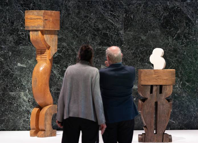 Besucher betrachten in der Neuen Nationalgalerie die Werke „Karyatide“ und „Schüchternheit“ des Bildhauers Constantin Brancusi.