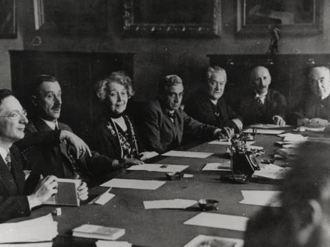 Sitzung der Sektion für Dichtkunst, 1929: Alfred Döblin, Thomas Mann, Ricarda Huch, Bernhard Kellermann, Hermann Stehr, Alfred Mombert, Eduard Stucken (v.l.n.r.) – Personengruppe um einen Tisch; sieben Erwachsene in Anzug; Papiere und Schreibmaschine auf dem Tisch; Schwarzweißfoto.