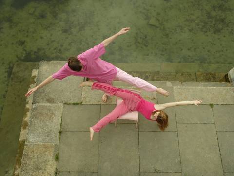 Chipp*ies Potsdam mit "Stuhltanz" – Zwei Performer*innen von oben fotografiert. Sie tragen pinke Kleidung und machen große Bewegungen auf einem Stuhl.