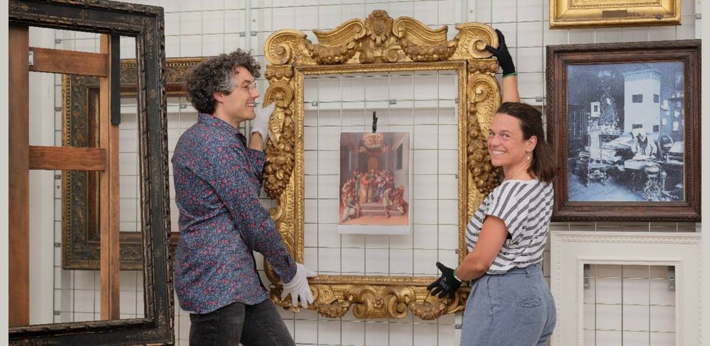 Blick in das Rahmenrestaurierungsatelier. Bertram Lorenz (li.) und Nadin Radecke (re.) stehen vor dem Sansovino-Rahmen.