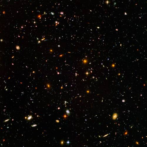 Hubble Ultra Deep Field (2018). Kompositbild des fernen Universums, erstellt auf Grundlage von Beobachtungen des Hubble-Weltraumteleskops – Verschiedene Galaxien und Sterne in einem dunklen Universum verteilt, leuchtend in unterschiedlichen Farben und Formen.