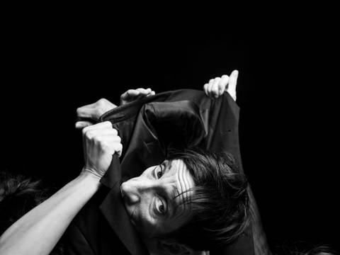 Joyful Failure – Ein Abend über die Poesie des Scheiterns 1 – Schwarz-weiße Aufnahme von zwei Performer*innen, eine in einem Sakko verschlungen.