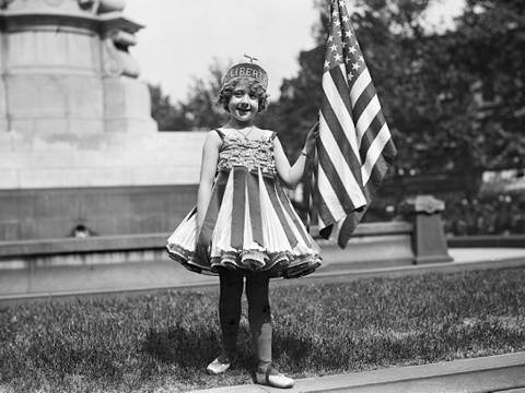 New England Holiday: Ein Mädchen feiert den 4. Juli 1916 als personifizierte Freiheit. – Kostümiertes Mädchen mit US-Flagge