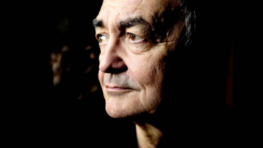 Älter wirkende Person im Profil mit ernstem Blick, dunkler Hintergrund, Licht betont Gesichtsfalten und Haaransatz.