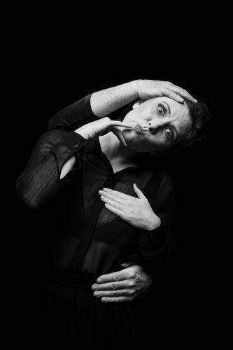 Joyful Failure – Ein Abend über die Poesie des Scheiterns 3 – Schwarz weiß Foto einer Person in schwarzen Klamotten, die von hinten von Armen umschlungen wird und eine Grimasse zieht.