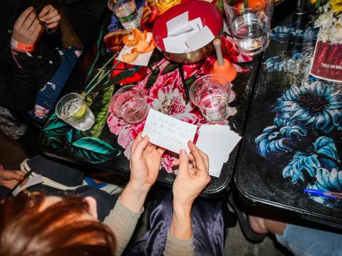 Jugendliche an einem Tisch mit Getränken und Zetteln in der Hand – Jugendliche an einem Tisch mit Getränken und Zetteln in der Hand