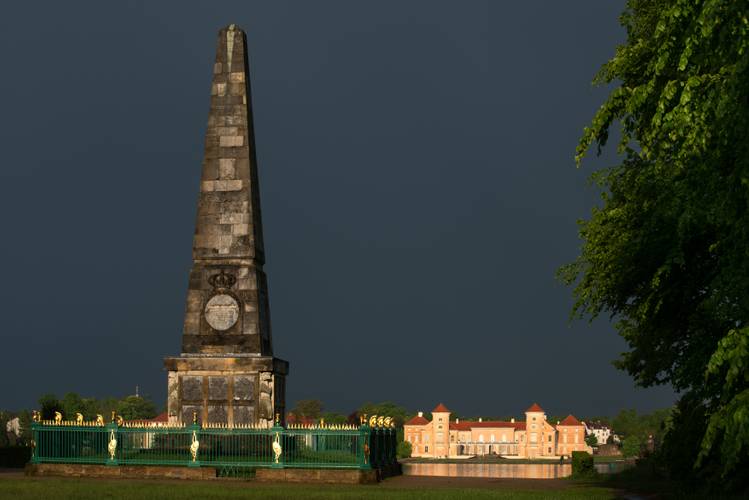 Obelisk im Lustgarten Rheinsberg, im Hintergrund das Schloss – Obelisk im Lustgarten Rheinsberg, im Hintergrund das Schloss